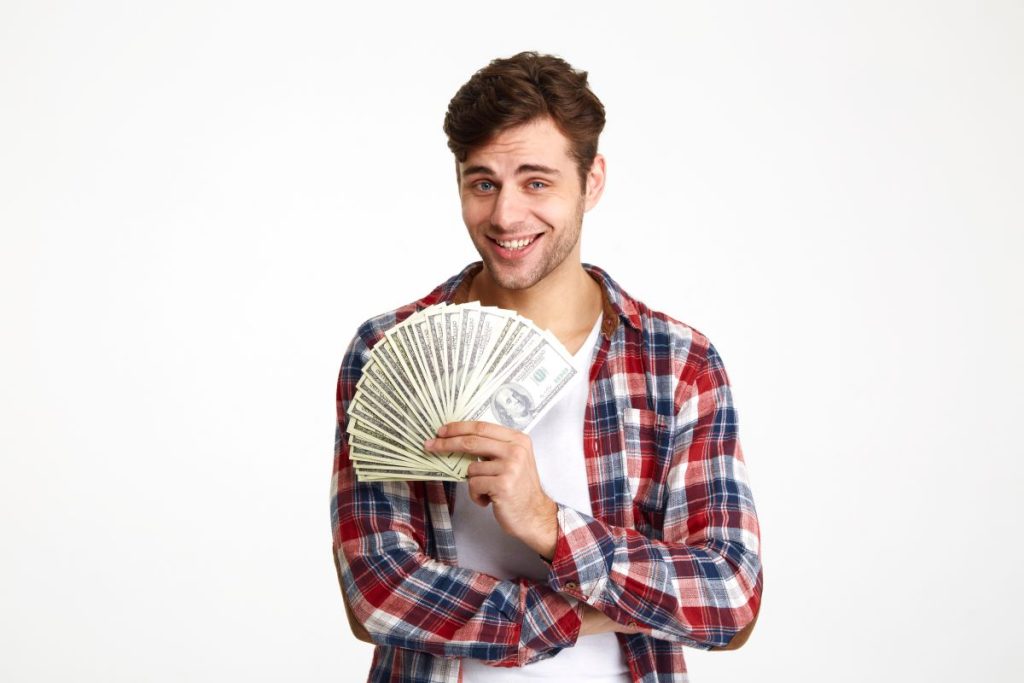 man holding dollar bills excited