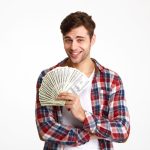 man holding dollar bills excited